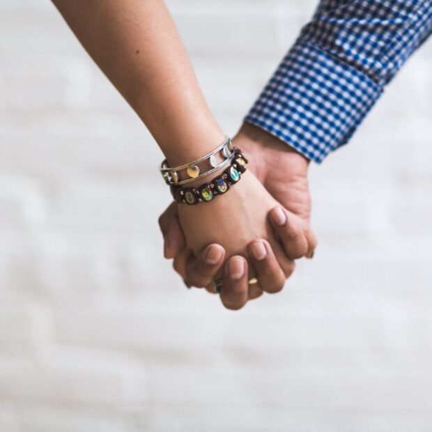 Canva - Couple Holding Hands Near White Painted Wall