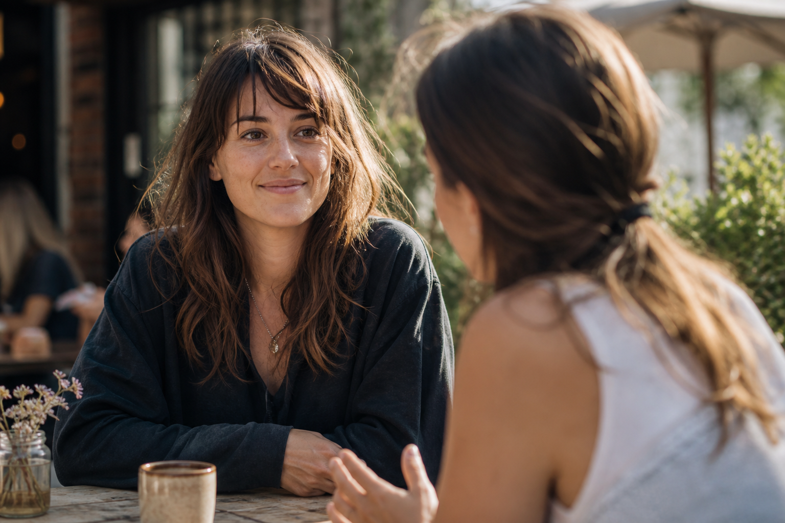 Two friends at an outdoor cafe, present and at ease with each other